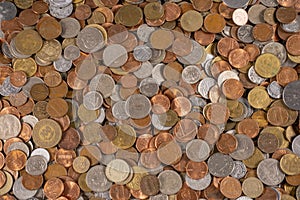 Group of different coins scattered on a flat surface