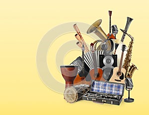 Group of different musical instruments on yellow background, space for text