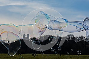 Group of Differently Sized Bubbles Floating Top of Munich Landscape