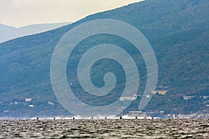 Group of distant jet ski watercraft drivers in open Black Sea