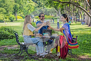 Group of diverse asian university LGBTQ student classmate as teamwork doing group homework together in campus park