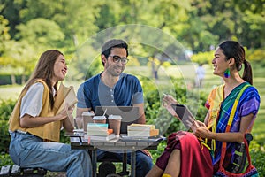 Group of diverse asian university LGBTQ student classmate as teamwork doing group homework together in campus park