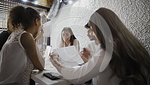 Group of diverse business executives holding a meeting around a table discussing graphs charts showing statistical data