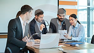 Group of diverse business people having brainstorming meeting, discussing and reviewing paperwork at office.