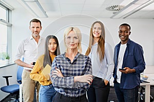 Group of diverse business people in office with female leader in front