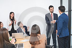 Group of diverse business people shaking hands, finishing up a deal or meeting. Businessman and businesswoman in formal suits