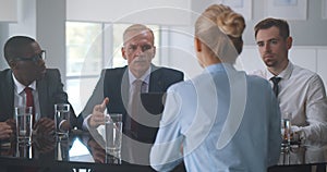 Group of diverse business people working and communicating while sitting at office desk together