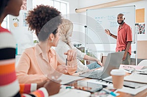 Group of diverse businesspeople having a meeting in a modern office at work. Young african american businessman smiling