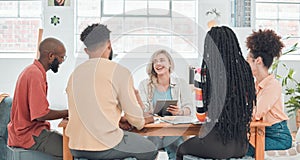 Group of diverse businesspeople having a meeting in a modern office at work. Young happy caucasian businesswoman smiling