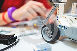 Group of diverse children kids with robotic vehicle model, close-up view on hands, science and engineering lesson in a classroom,