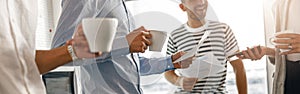 Group of diverse coworkers drink coffee during break and talking about work project