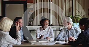 Group of diverse employees gathered in boardroom for training