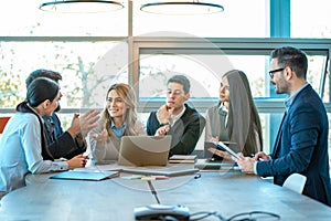 Group of diverse executives having brainstorming business meeting at conference table in office.