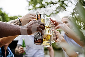 Group of diverse friends celebrating drinking beers together