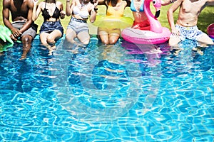 Group of diverse friends enjoying summer time by the pool with i
