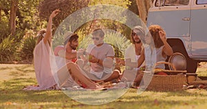 Group of diverse friends having lunch and enjoying in the park while having a picnic