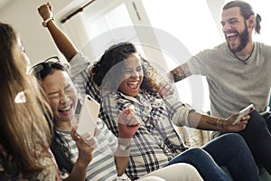 Group of diverse friends playing game on mobile phone