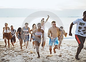 Group of diverse friends running at the beach together