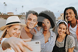 Group of diverse friends taking a selfie at the beach