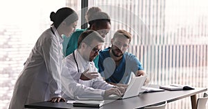 Group of diverse general practitioners engaged in teamwork using computer