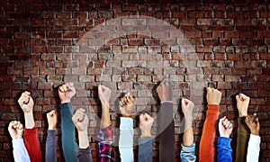 Group of Diverse Hands Raised on Brick Wall