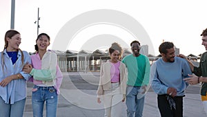 Group of diverse happy friends having fun hanging out together outdoors.