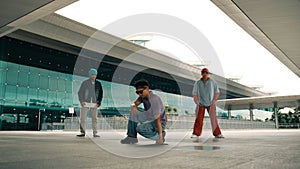 Group of diverse hipster or dancer doing head spin in front of mall. Sprightly.