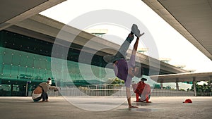 Group of diverse hipster or dancer doing head spin in front of mall. Sprightly.