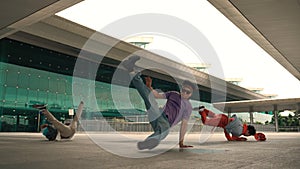 Group of diverse hipster or dancer doing head spin in front of mall. Sprightly.