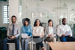 Job applicants sitting together in an office waiting for interviews photo