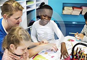 Group of diverse Kids coloring workbook in class photo