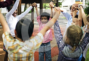 Group of diverse kindergarten students hands up together