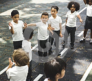 Group of diverse kindergarten students standing in line at playground