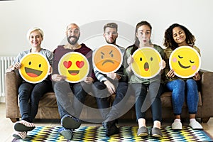 Group of diverse people holding emoticon icons