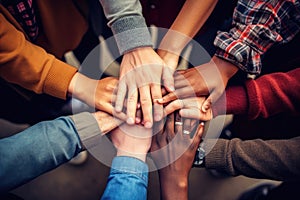 Group of diverse people putting their hands together on top of each other, A group of diverse hands holding each other in support