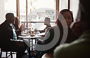 Group of diverse people sitting at tables in a cafe