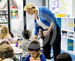 Group of diverse students coloring workbook in class