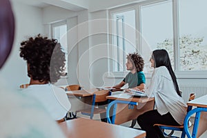 A group of diverse students engages in lively discussion as they educate themselves in a modern classroom, embracing the