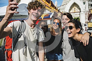 Group of diverse tourists taking selfie in Thai temple Thailand