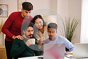 Group of diverse university colleagues studying together at shared flat.