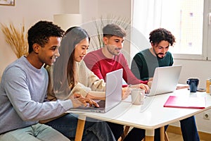 Group of diverse university colleagues studying together at shared flat.