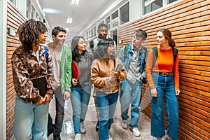 Multi ethnic students walking and talking in university hallway