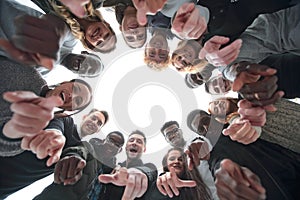 Group of diverse young people standing in a circle and pointing at you