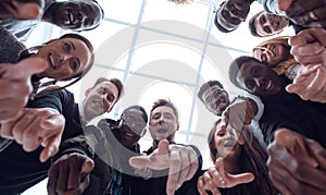 group of diverse young people standing in a circle and pointing at you