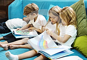 Group of Diverse Young Students Reading Children Story Book Together