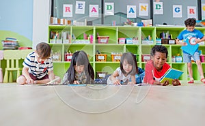 Group of diversity kid lay down on floor and reading tale book i photo