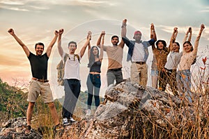 Group of diversity people having fun together climbing up rocky mountains to the peak