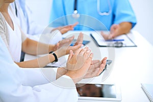 Group of doctors applauding at medical meeting. Close up of physician hands. Teamwork in medicine