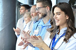 Group of doctors applauds, standing in the hospital