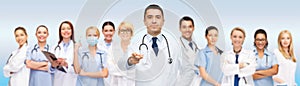 Group of doctors with clipboard pointing at you